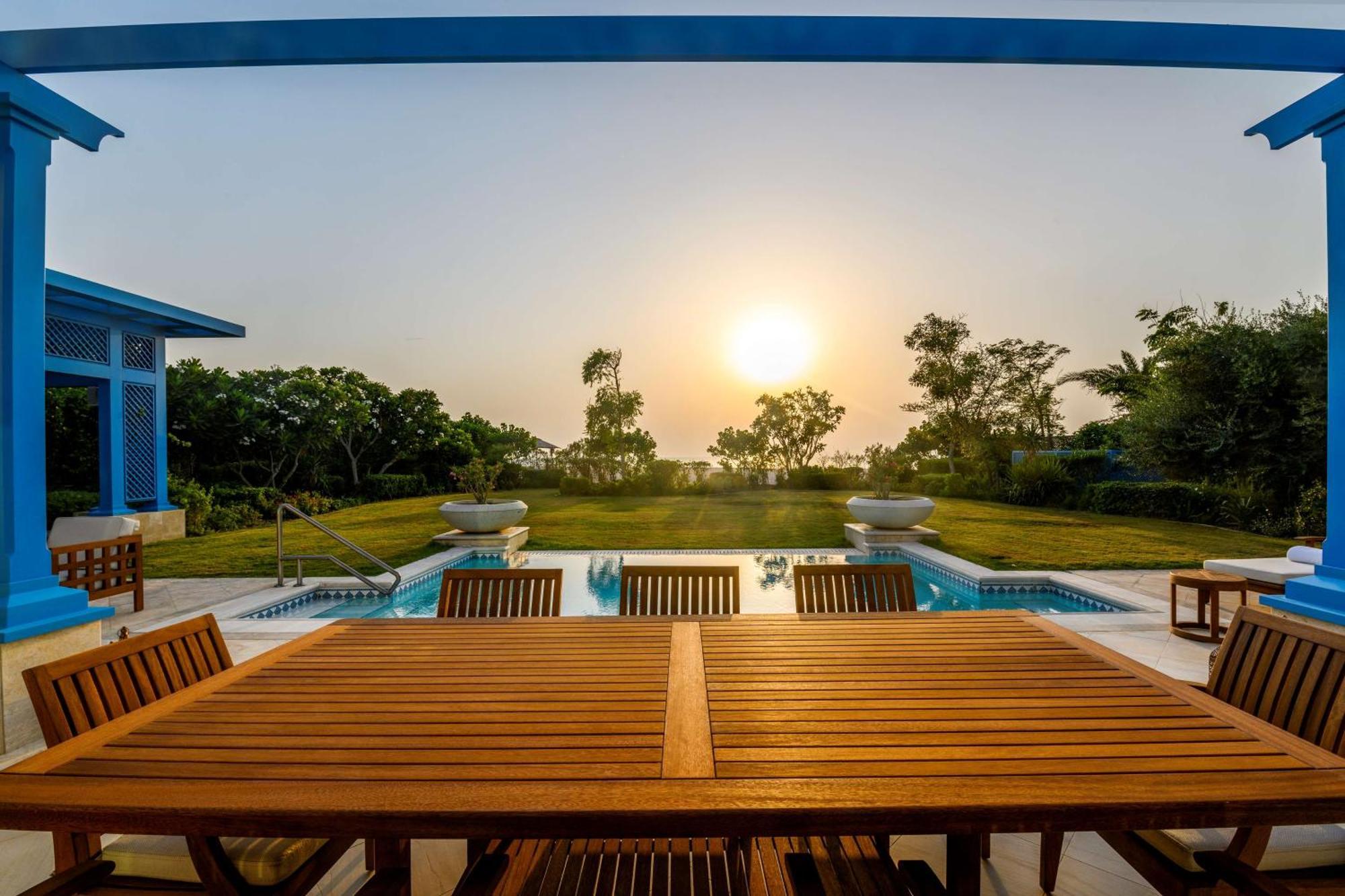 Hilton Salwa Beach Resort And Villas Abu Samra Esterno foto Sunset at the pool